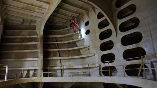 A rope access hull tank inspector conducting marine class inspections on an FPSO tank offshore