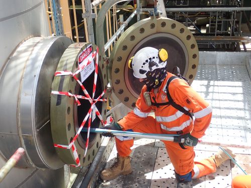 A technician inserting the Olympus digital camera into an open pipe adorned in safety tape.