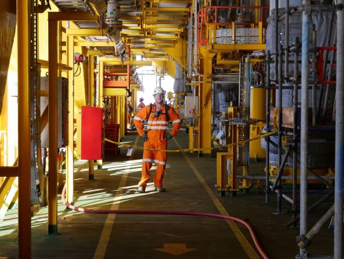 A vertech technician stops and poses for a photo onboard an fpso.loading=