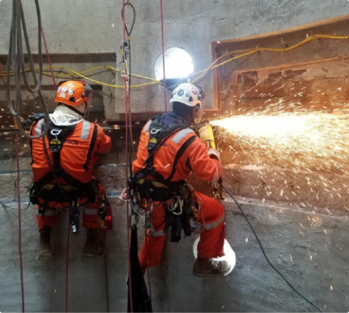 An image of rope access welders completing weld repairs during an LNG construction and commissioning project in the USA.