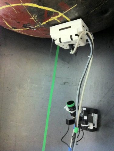 The image shows the innovative End Dome Robotic Inspection System (EDRIS) developed by Sonomatic, mounted on the interior of a vertical pressure vessel. This cutting-edge robotic scanner is designed to perform inspections without manned entry, significantly enhancing safety by minimising the risks associated with confined space operations. It can perform remote operations, steering, and full rotation on its axis, producing data contributing to statistical analysis for non-invasive inspection justifications.