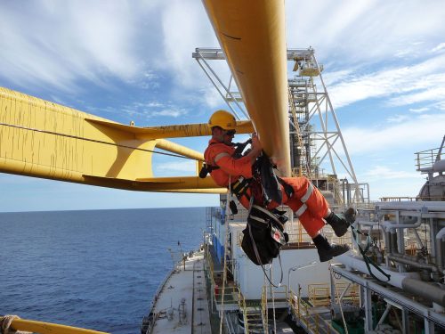 A vertech IRATA rope access technician hangs suspended from some structural beams onboard the FPSO.