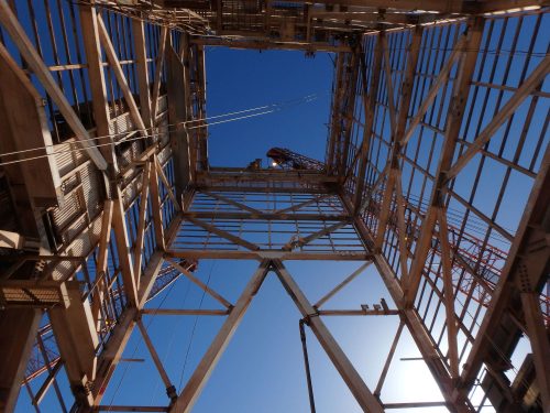 A shot from beneath a derrick looking upwards showing the process of decommissioning.