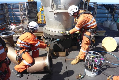 Two vertech technicians fastening the bolts of a new flare tip installed on Goodwyn Alpha.
