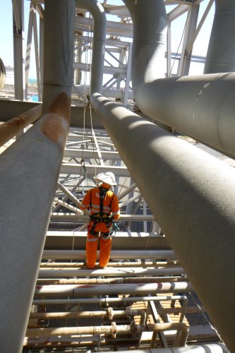 A Vertech IRATA rope access inspector is conducting close visual inspections of pressure piping on the Karratha Gas Plant (KGP) in the Pilbara.