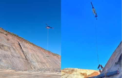 Two images spliced together to show a helicopter lowering a roll of TECCO mesh on the rope to 2 IRATA rope access technicians on a sloped rockface with a clear blue sky in the background.