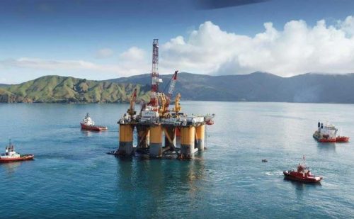 An image of a semi submersible drill rig being towed from location in new zealand