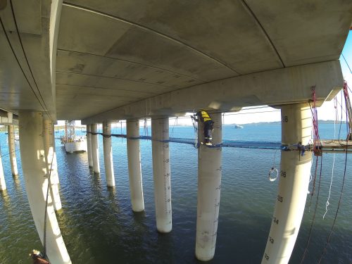 Two Vertech IRATA rope access technicians are installing the tension netting under the Gladstone LNG facility.