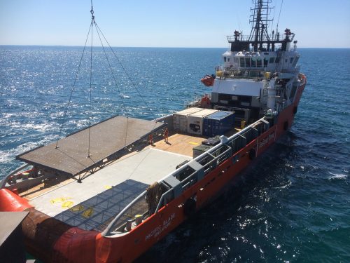 Steel grating being lowered onto a barge.