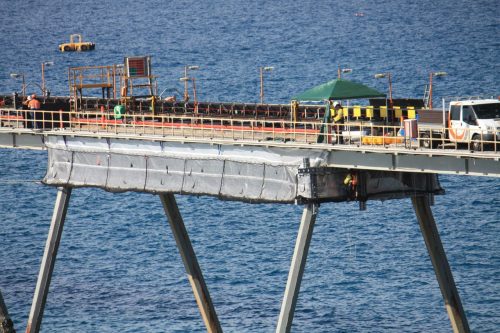 The same long shot of a bridge, with tension netting installed to allow alternative access to perform testing and repairs on the underside.