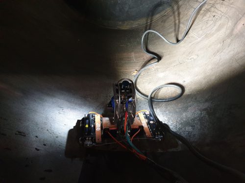 An RDVI Drone is driving around inside a tank, lighting the path ahead.
