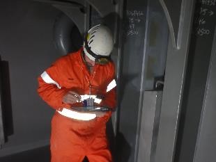 A marine class inspector inside a ballast tank conducting hull survey inspections as part of an ongoing FPSO class survey cycle.