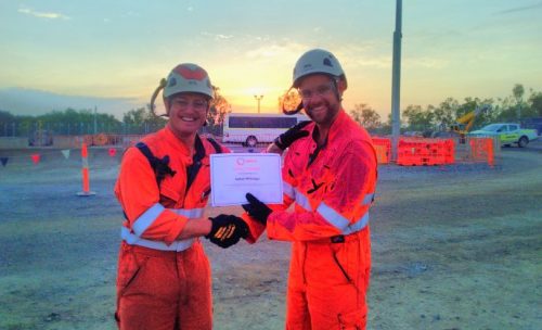 A vertech supervisor awarding a rope access technician with a safety award on an LNG project