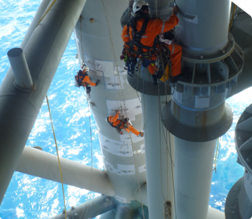 A rope access team on an offshore production platform conducting coating repairs, remediation and passivation on the jacket structure.