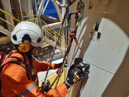 A rope access, Non destructive testing (NDT) technician conducting phased array roller probe inspection on the external of a pressure vessel offshore