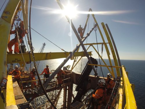 Vertech technicians work on decommissioning a derrick.