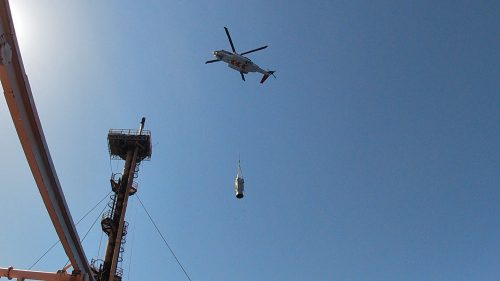 A helicopter carrying in material as part of a flare tip change out on the NRC.