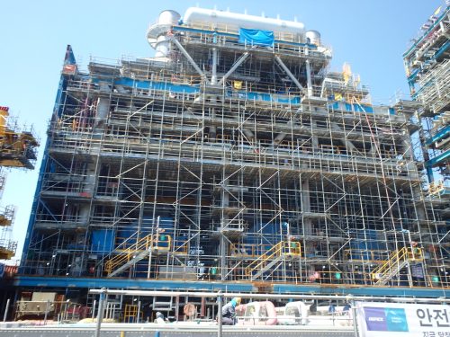 Scaffolding spreads about the side of a platform as construction continues.