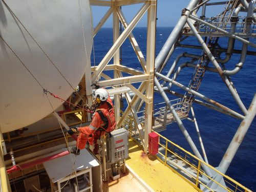 A vertech IRATA Rope Access Technician hangs suspended from ropes during an NDT inspection.