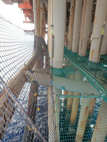 Tension netting installed across the miday points of pillars attached to the underside of the NRA platform, with ocean below.