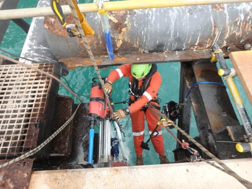 A Vertech IRATA Rope access Tradesman conducting core drilling via overwater rope access.