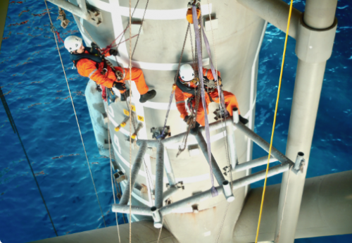 An IRATA rope access rigging team working over water hauling a section of steel into place as part of a subsea tieback program.