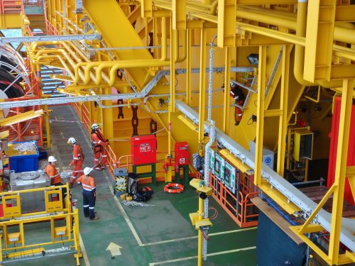 A team of Vertech technicians are gathered around on the deck of the ICHTHYS Venturer FPSO.