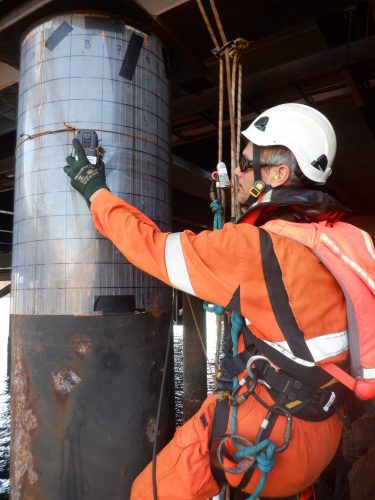 A vertech technician using specialist equipment to map corrosion on a jetty support beam.
