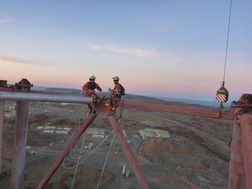 A vertech rope access technician performs repairs on a flare at the pluto lng facility.