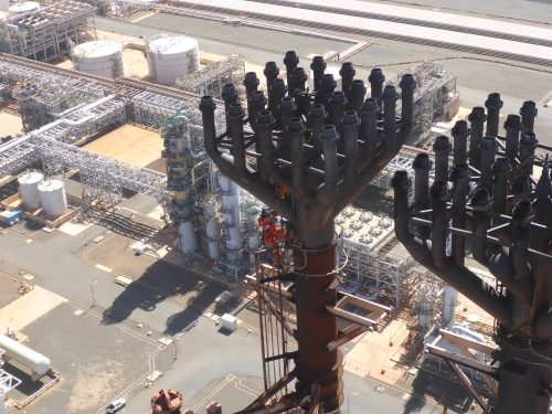 A vertech rope access technician performs repairs on a flare at the pluto lng facility.