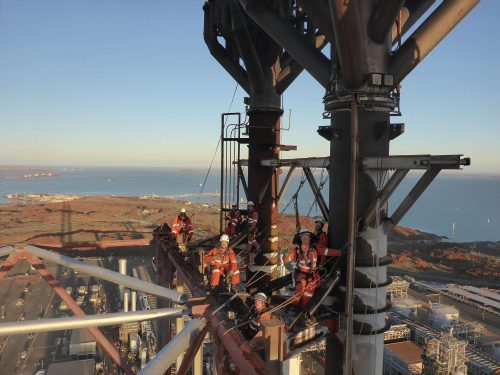 A vertech rope access technician performs repairs on a flare at the pluto lng facility.