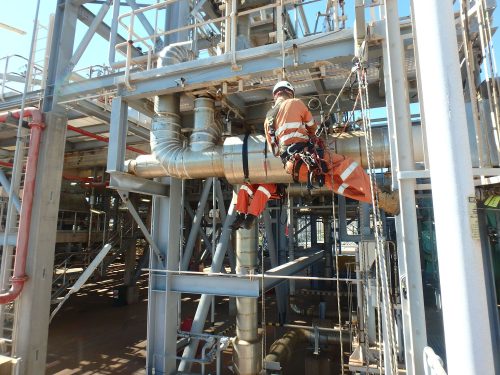 A vertech IRATA rope access technician suspended on ropes inspects plant infrastructure as part of a baseline inspection service.