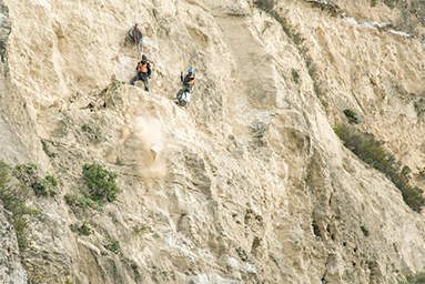 Rocky cliff with Abseil Access technicians at work.