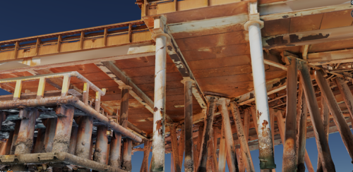 The image is a 3D rendering showing the detailed understructure of an offshore platform. The focus is on the corroded metal beams and pillars that form the substructure, with the textures and colouration suggesting advanced stages of rust and material degradation. Above, the platform’s deck is visible, providing a sharp contrast to the worn conditions of the support elements below. The perspective offers a clear view of the engineering complexity and maintenance challenges faced in the harsh marine environment. The visualisation technique provides clarity and depth, highlighting areas of concern for structural integrity assessments. The image is a 3D rendering showing the detailed understructure of an offshore platform. The focus is on the corroded metal beams and pillars that form the substructure, with the textures and colouration suggesting advanced stages of rust and material degradation. Above, the platform’s deck is visible, providing a sharp contrast to the worn conditions of the support elements below. The perspective offers a clear view of the engineering complexity and maintenance challenges faced in the harsh marine environment. The visualisation technique provides clarity and depth, highlighting areas of concern for structural integrity assessments.