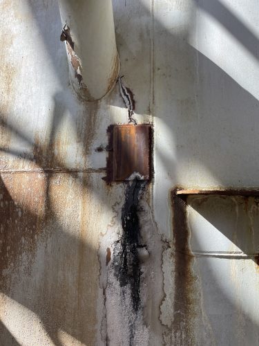 A close-up image showing some damage to refinery equipment.