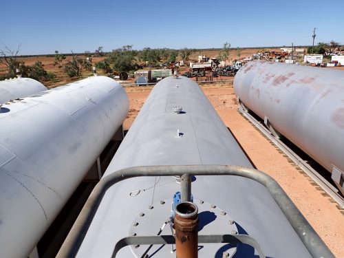 The top of a fuel tanker overlooks desert scenery in the background.