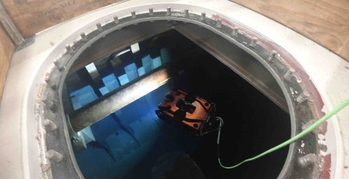 An ROV is submerged into a tank to begin carrying out testing duties.