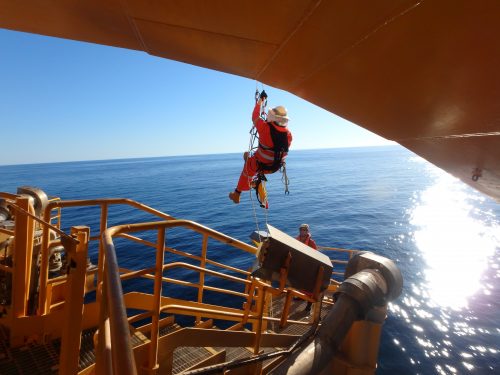 A rope access technician working above water on an FPSO Riser turret mooring (RTM) offshore A rope access technician working above water on an FPSO Riser turret mooring (RTM) offshore