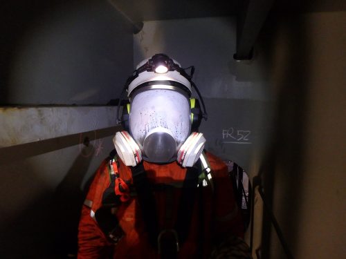 A vertech technician posing for a photo with a fogged up full face mask.