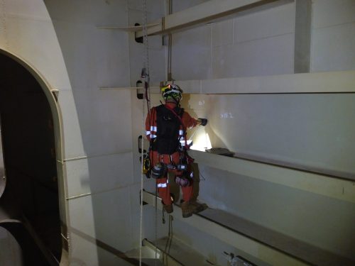 A vertech IRATA rope access ndt technician inspecting the wall of a hull of the ningaloo vision fpso.