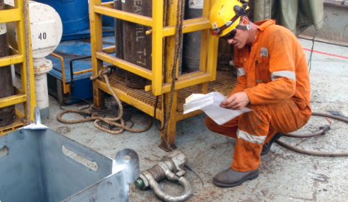 A lifting equipment inspector conducting NDT on a lifting basket and visual inspection of lifting geat as part of an upstream detill rig survey.