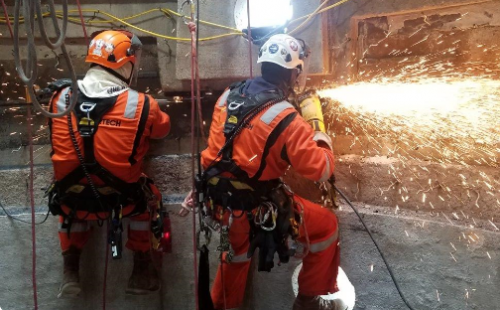 An IRATA rope access team conducting specialist maintenance services in the infrastructure sector.