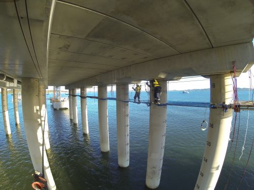 Two Vertech IRATA rope access technicians are installing the tension netting under the Gladstone LNG facility.