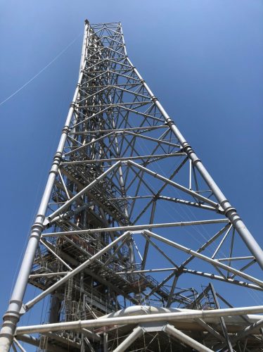 The view from below of a derrick structure.