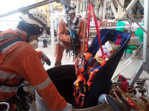 A Vertech marine class emergency rescue team conducting rescue practice recovering a mock casualty from a tank offshore.