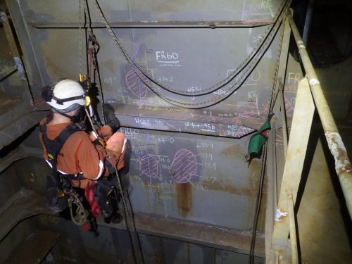 A Rope Access NDT inspector taking ultrasonic readings as part of a marine class project on ) of an FPSO offshore